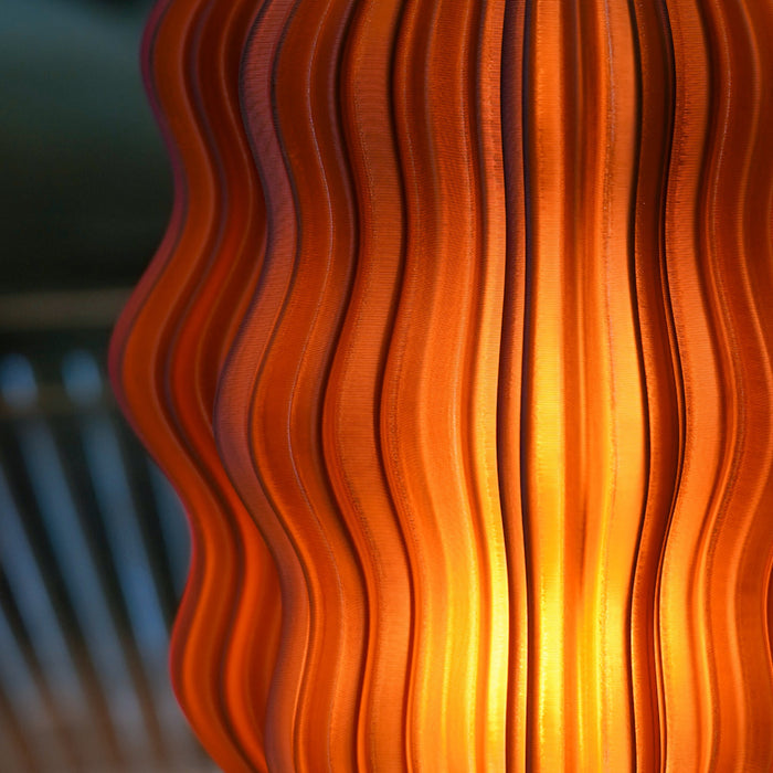 Close-up of Wooj Design cordless mini wavy amber lamp showing textured surface and warm glow.