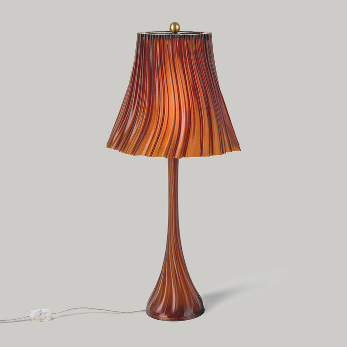 Wooj Design Pleat Lamp with a sleek, amber-colored pleated lampshade illuminating a modern interior space.