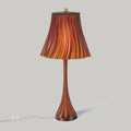 Wooj Design Pleat Lamp with a sleek, amber-colored pleated lampshade illuminating a modern interior space.