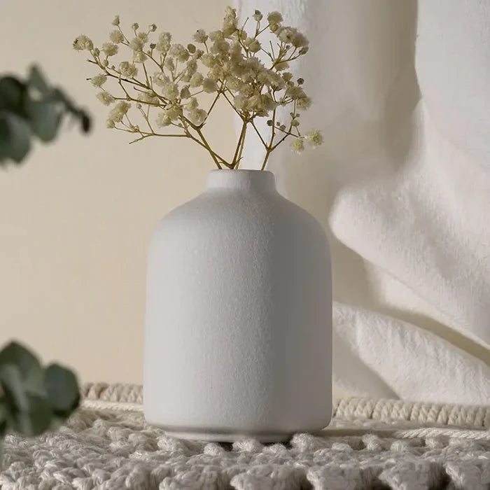 Simple ceramic vase with a smooth white finish, ideal for floral arrangements or decorative display.